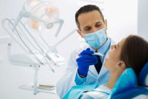 Dentist performing dental examination on female patient