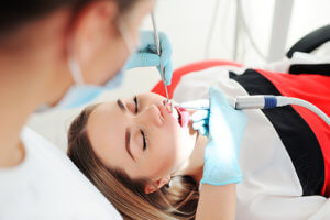 Woman in dentist chair experiencing wisdom teeth removal