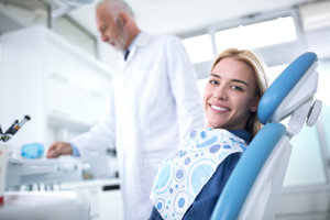 Smiling woman in dentist chair after tooth decay treatment