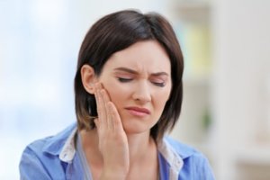 Woman with jaw pain in need of TMJ treatment